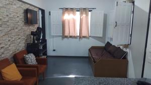 a living room with a couch and a window at Vila mar azul in Imbassai