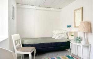 Un pequeño dormitorio con una cama y una silla. en Nice Home In Sejerø With Wifi, en Sejerby 24 fotos más