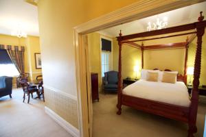 Carrington Hotel في كاتومبا: غرفة نوم بسرير مظلة وغرفة معيشة