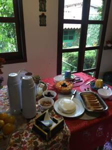 un tavolo con una tovaglia rossa con del cibo sopra di Recanto da Deusa a Bocaina de Minas