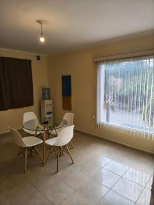 ein Esszimmer mit Tisch und Stühlen und einem Fenster in der Unterkunft Quique1 in Pilar + 1 Foto