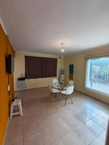 ein Wohnzimmer mit Tisch und Stühlen und einem Fenster in der Unterkunft Quique1 in Pilar