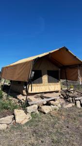 Maanzoni backpackers infinity camp grounds في Kenplains: خيمة كبيرة موضوعة فوق بعض الصخور