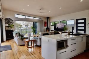 a kitchen and living room with a couch and a table at Paradise - Spacious, Ocean Views, Outdoor Living in Dodges Ferry