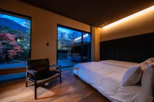 由布市にあるHotel MODAのベッドルーム1室(ベッド1台、椅子、大きな窓付)