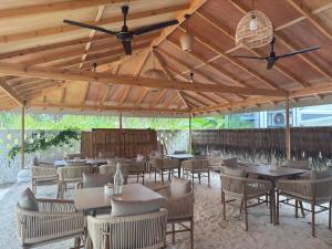 Belena Maldives في ثودو: مطعم بطاولات وكراسي تحت سقف خشبي