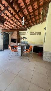 Exclusividade! Paraíso na Praia في ساو سيباستياو: فناء به كراسي برتقالية ومطبخ خارجي