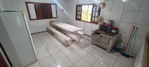 a kitchen with a bench and a stove in a room at Chácara mobiliada próximo Criciúma Br101 in Araranguá