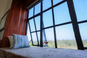 a glass of wine sitting on a table in front of a window at Kokasemera Country Villa in Fort Portal +59 photos