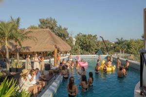 a group of people in a pool at a resort at Mayan Monkey Tulum - Social Hotel in Tulum