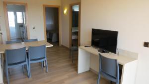 a room with a table with chairs and a television at Apartaments Players in Malgrat de Mar