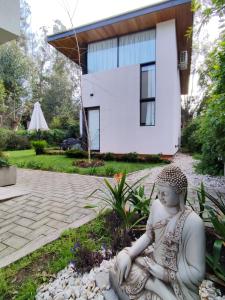 a statue of a woman sitting in front of a house at Rincon de Luna, Cabañas in Mar del Plata +10 photos