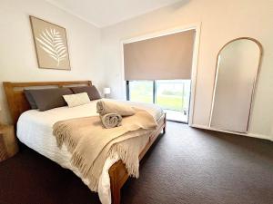 En eller flere senge i et værelse på 3 Bedroom Townhouse near Caves Beach