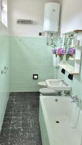 een badkamer met 2 toiletten, een wastafel en een bad bij Villa Due Cieli 1 in Lanzo dʼIntelvi