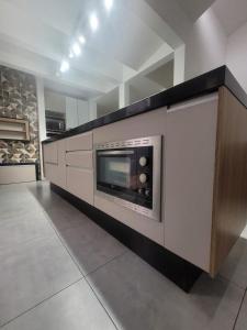 a kitchen with a microwave on a wall at Casa espaçosa no coração de Floripa in Florianópolis