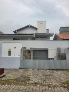 a white building with a fence in front of it at Casa espaçosa no coração de Floripa in Florianópolis +55 photos