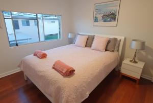 ein Schlafzimmer mit einem Bett und zwei Kissen darauf in der Unterkunft Sensational Waterfront Apartment in Dunbogan