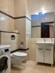 ein Badezimmer mit Toilette, Waschbecken und Waschmaschine in der Unterkunft Platinum Towers High floor in Warschau