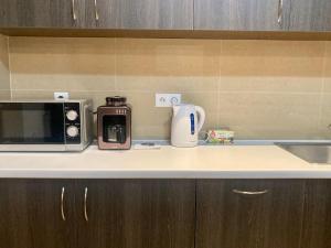 eine Küchentheke mit einer Mikrowelle und einer Kaffeemaschine in der Unterkunft Platinum Towers High floor in Warschau + 6 Fotos