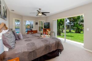 a bedroom with a large bed with a ceiling fan at Alecia in Cape Coral