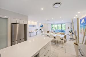 cocina con electrodomésticos blancos y comedor en Poinciana Lodges, en Hamilton Island