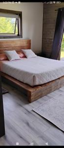 a bedroom with a wooden bed with a window at Hermosa casa en Palguin Bajo, Pucon in Minetué