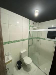 a bathroom with a toilet and a glass shower at Pé na Guarita in Torres +5 photos
