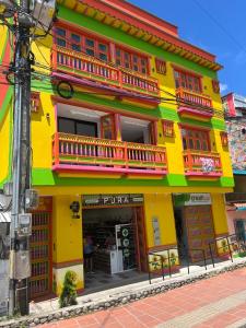 a yellow building with red and green trim at Girasoles del parque in Estación El Salto