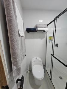 a white bathroom with a toilet and a shower at Girasoles del parque in Estación El Salto