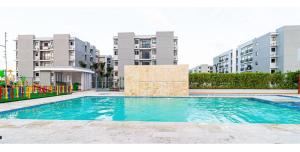 a swimming pool in front of some apartment buildings at Caribbean Breeze in Punta Cana