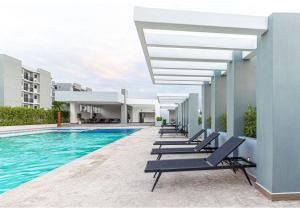 a row of lounge chairs next to a swimming pool at Caribbean Breeze in Punta Cana