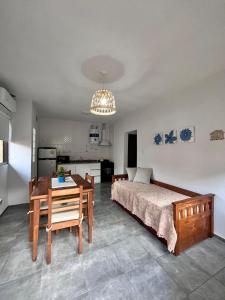 ein Schlafzimmer mit Bett und Tisch und eine Küche in der Unterkunft Complejo Entre Parras in San Rafael