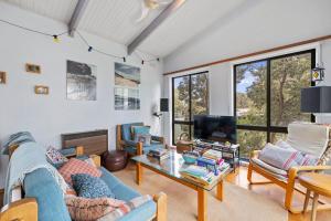 a living room with a couch and a table at Treehouse at Cape in Cape Paterson