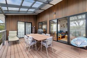 a dining room with a table and chairs on a deck at Treehouse at Cape in Cape Paterson +14 photos