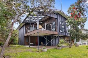 a modern house with a black facade at Treehouse at Cape in Cape Paterson