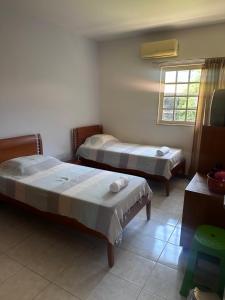 a room with two beds and a window at Casa do Sonho in Paripueira