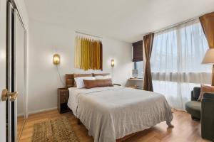 a bedroom with a bed and a chair and a window at The Landing at Kailua Bay in Kailua-Kona +24 photos