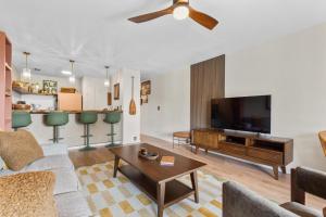 a living room with a couch and a flat screen tv at The Landing at Kailua Bay in Kailua-Kona