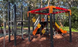 a playground with a slide in a park at Coastal Family Oasis with Pool, Outdoor Kitchen, Kids Play Area in Belmont