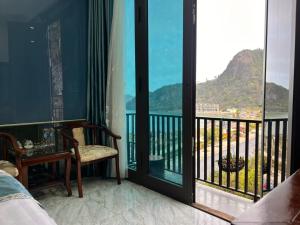 een slaapkamer met een balkon met uitzicht op de oceaan bij Sunrise Ocean Hotel & Rooftop Bar in Cat Ba