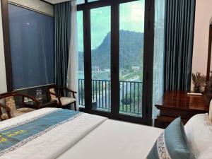 een slaapkamer met een bed en een balkon met uitzicht bij Sunrise Ocean Hotel & Rooftop Bar in Cat Ba