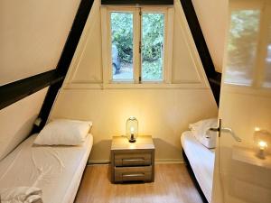 duas camas em um pequeno quarto com janela em Relaxing Ardennes Getaway in Durbuy em Septon