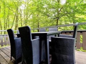 uma mesa e cadeiras sentadas num deque de madeira em Relaxing Ardennes Getaway in Durbuy em Septon mais 2 fotografias