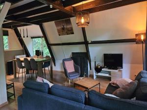 uma sala de estar com um sofá azul e uma TV em Relaxing Ardennes Getaway in Durbuy em Septon