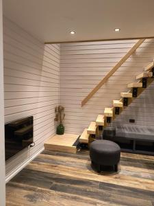 Una habitación con una cama y un banco y escaleras. en Refugio Maẅen, en Puqueldón