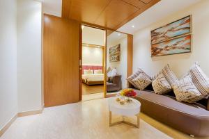 a living room with a couch and a table at Kiscol Grands Hotel in Coimbatore