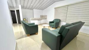 a living room with two chairs and a table at Hotel Campestre Cinco Estrellas in Villavicencio +14 photos