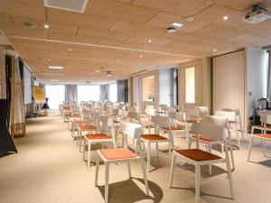 a room filled with white chairs and tables at ibis Styles Montauban in Montauban