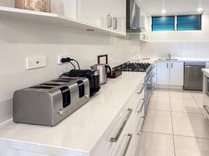 La cocina está equipada con tostadora, horno y encimera. en Poinciana Lodges, en Hamilton Island