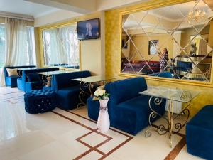 a living room with blue furniture and a mirror at Diamond Hotel in Chişinău